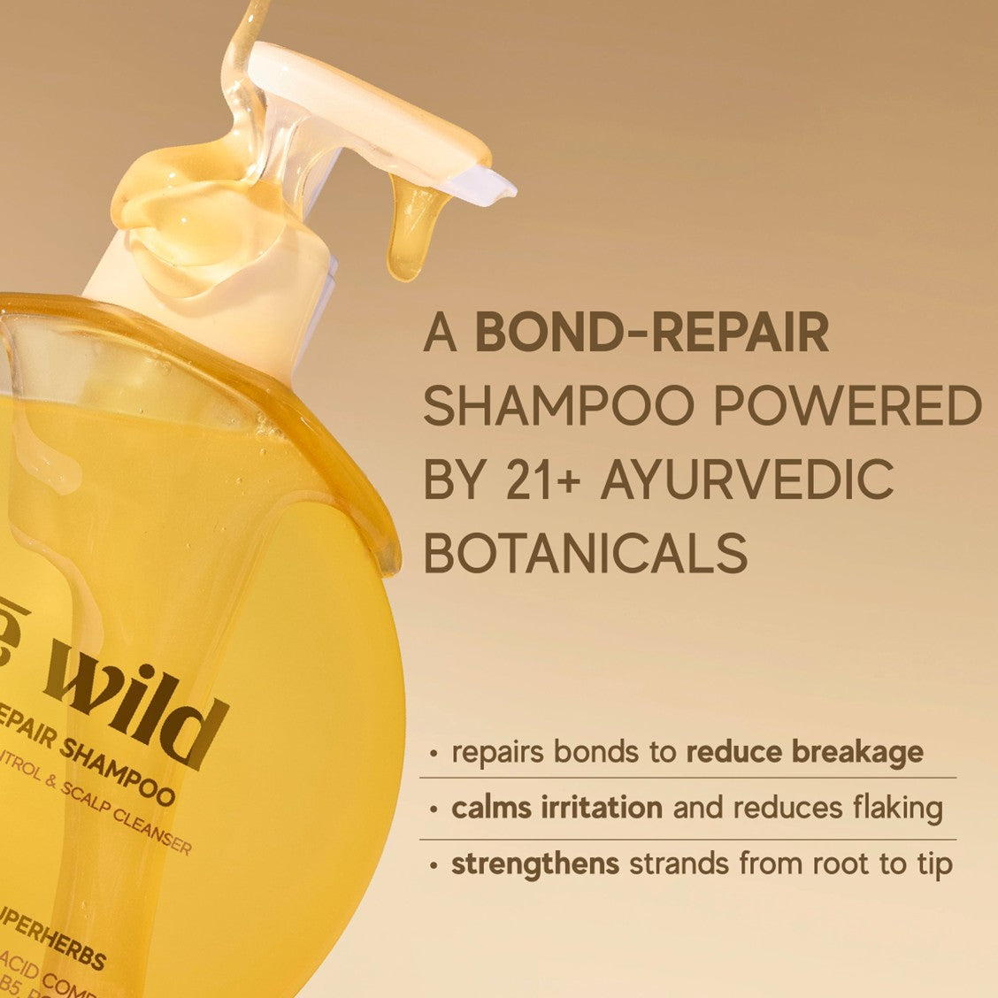 Inde Wild Shampoo bottle with pump and text about bond-repair shampoo and Ayurvedic botanicals on a beige background