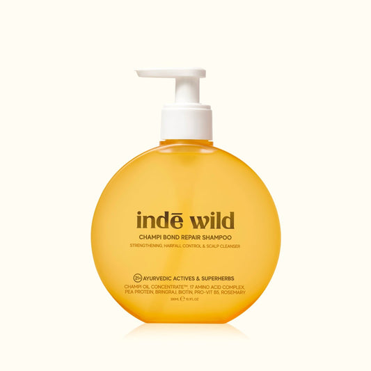 Yellow shampoo bottle with white pump labeled 'inde wild' on a white background