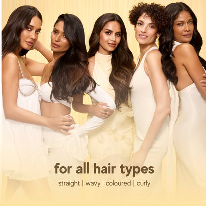 Five women with different hair types posing together on a beige background